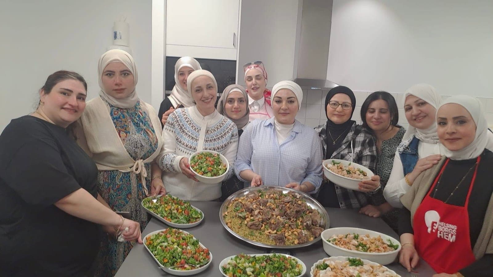 المجموعة مجتمعة خلف الأطباق الجاهزة في المطبخ