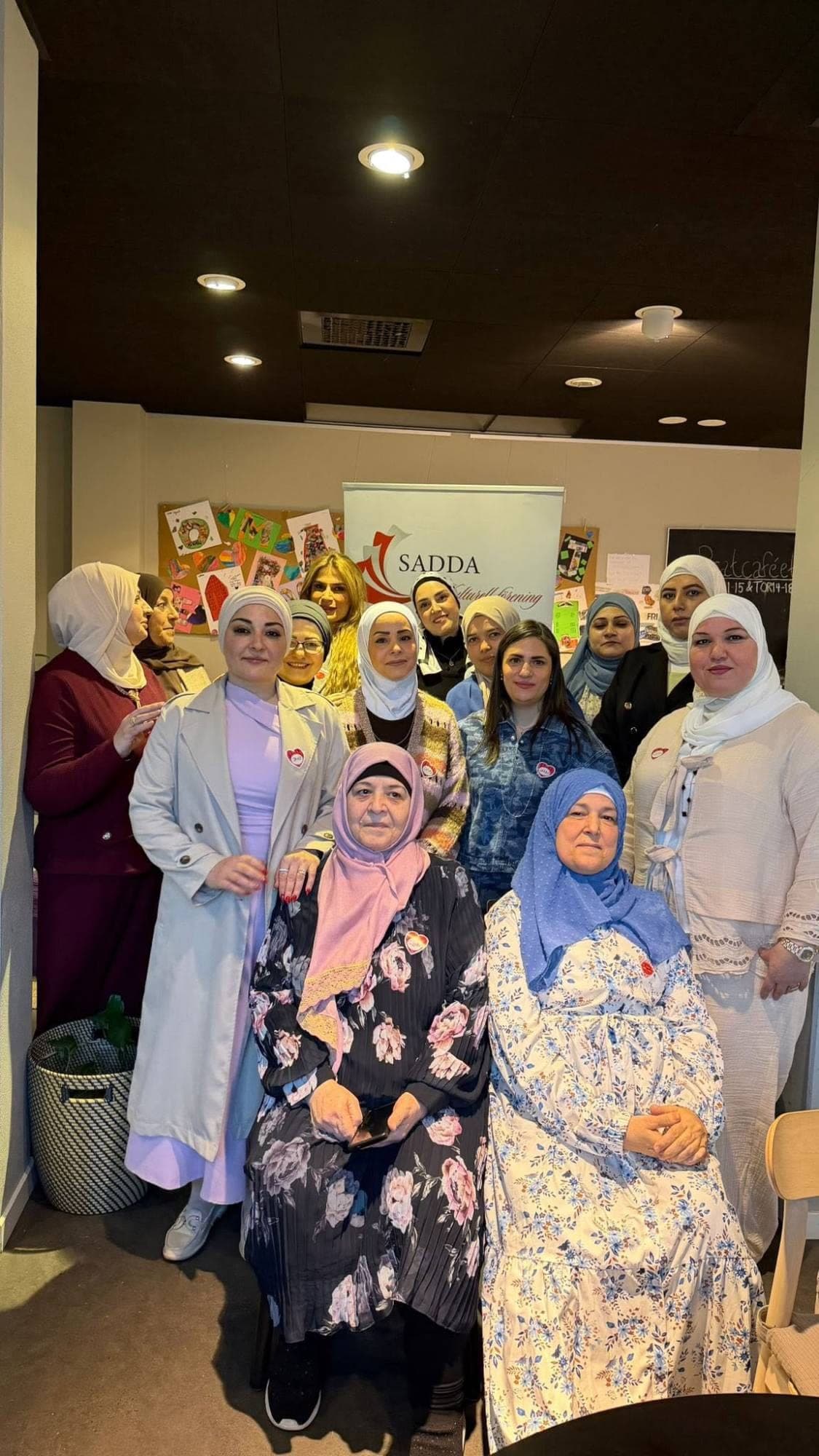 المجموعة مجتمعة حول السيدات الأكبر سنّاً في ختام الأمسية
